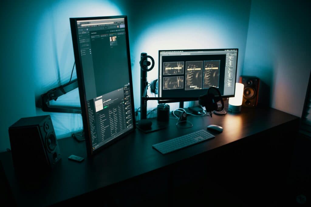 Desk with two monitors, a keyboard, and speakers (stock photo, to be replaced)