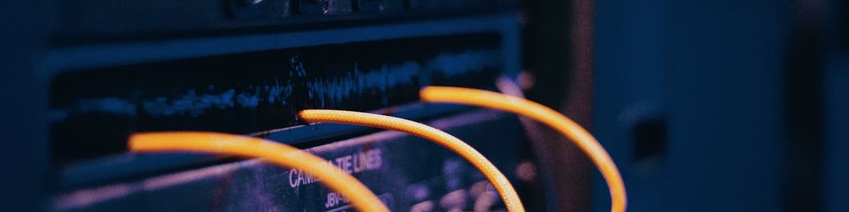 Close-up of network cables and ports in a server rack, showcasing connectivity.